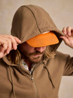 Olive cotton hoodie close-up: drawstring hood with orange interior lining