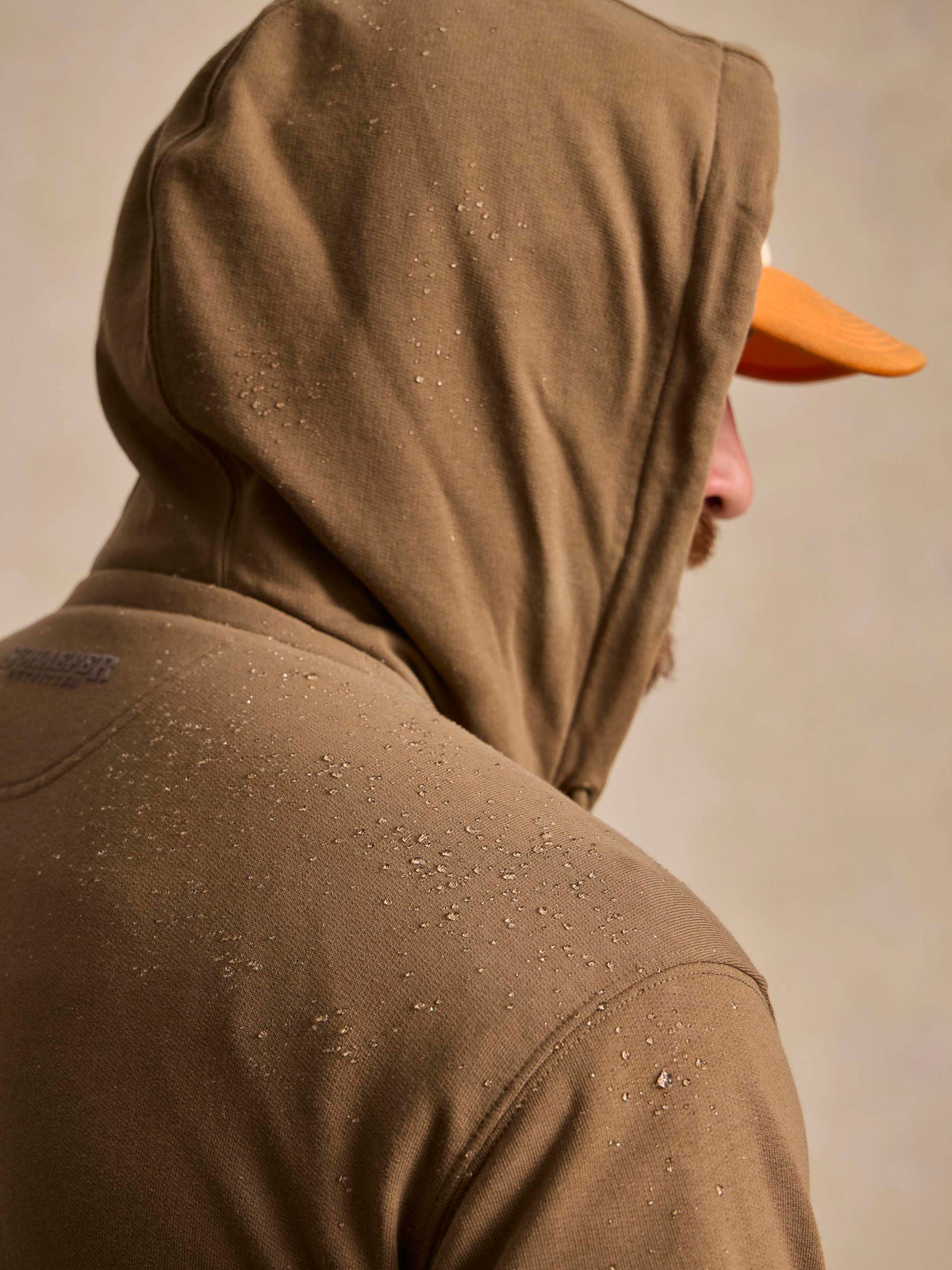 Olive cotton hoodie close-up of back hood and textured speckle finish