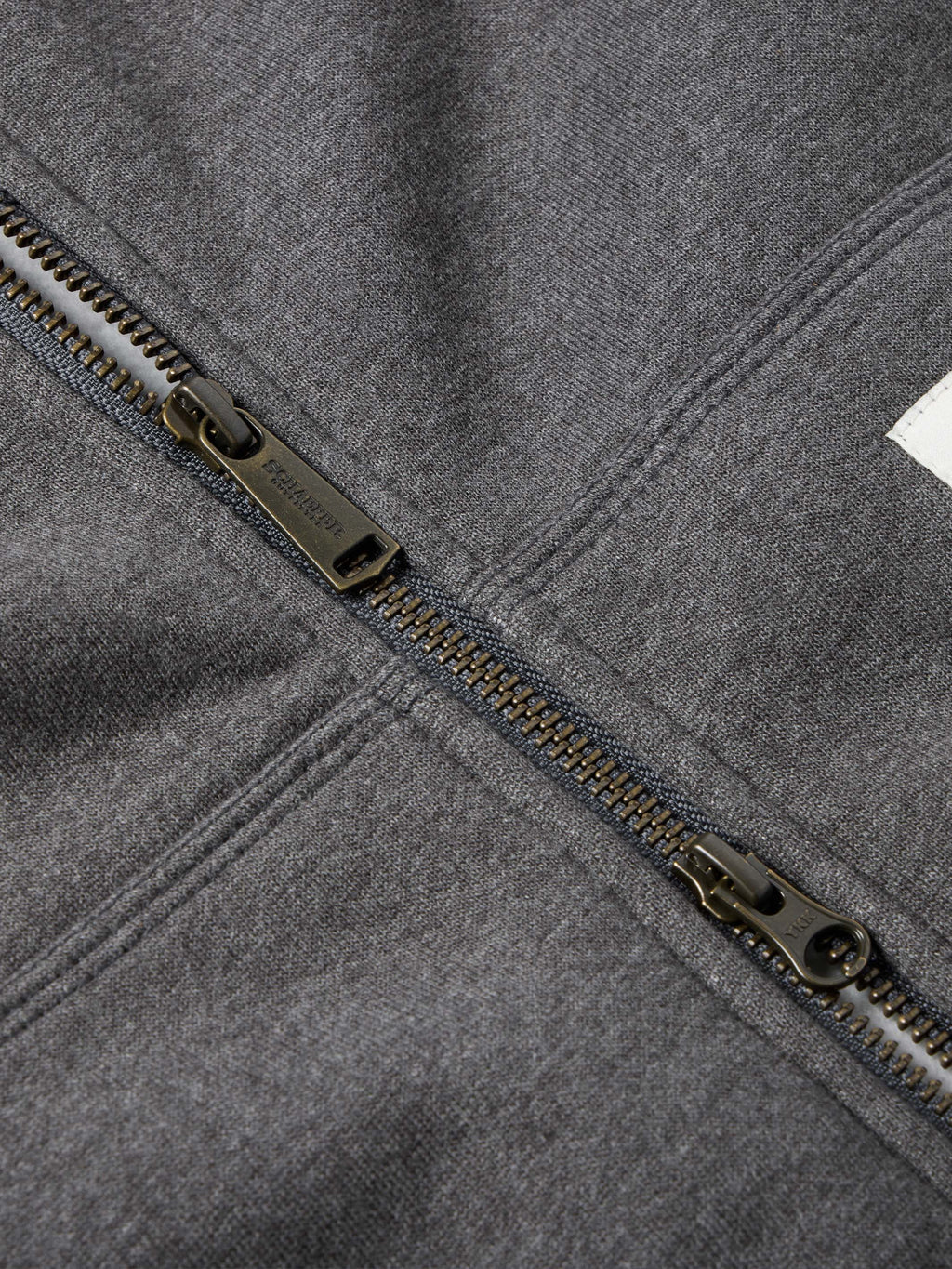 Heather charcoal zipper and seam detail with metal zipper pull and stitched edges