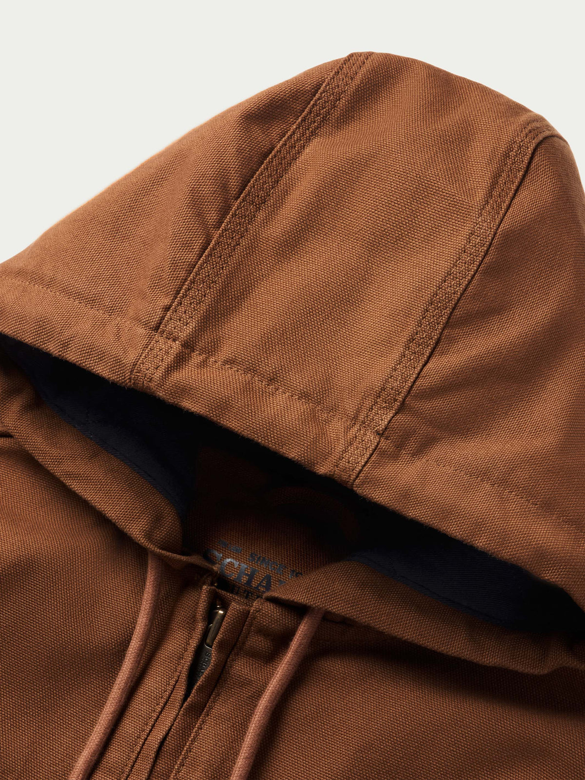 Russet hood edge close-up with navy lining and drawstring cords