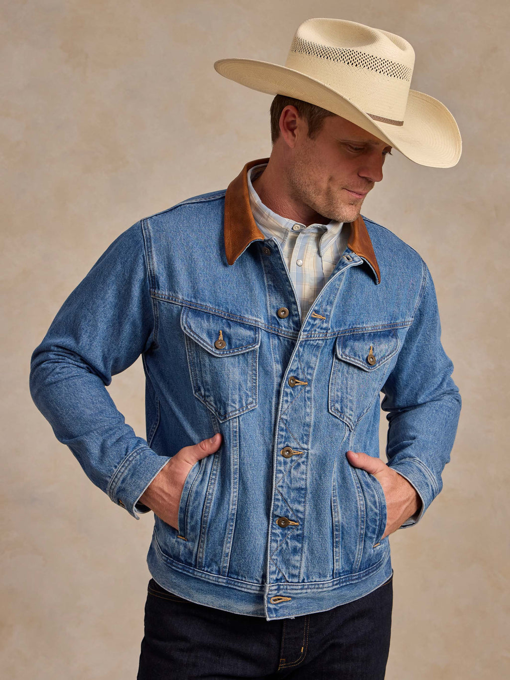 Medium indigo denim jacket worn by model with brown collar and flap pockets