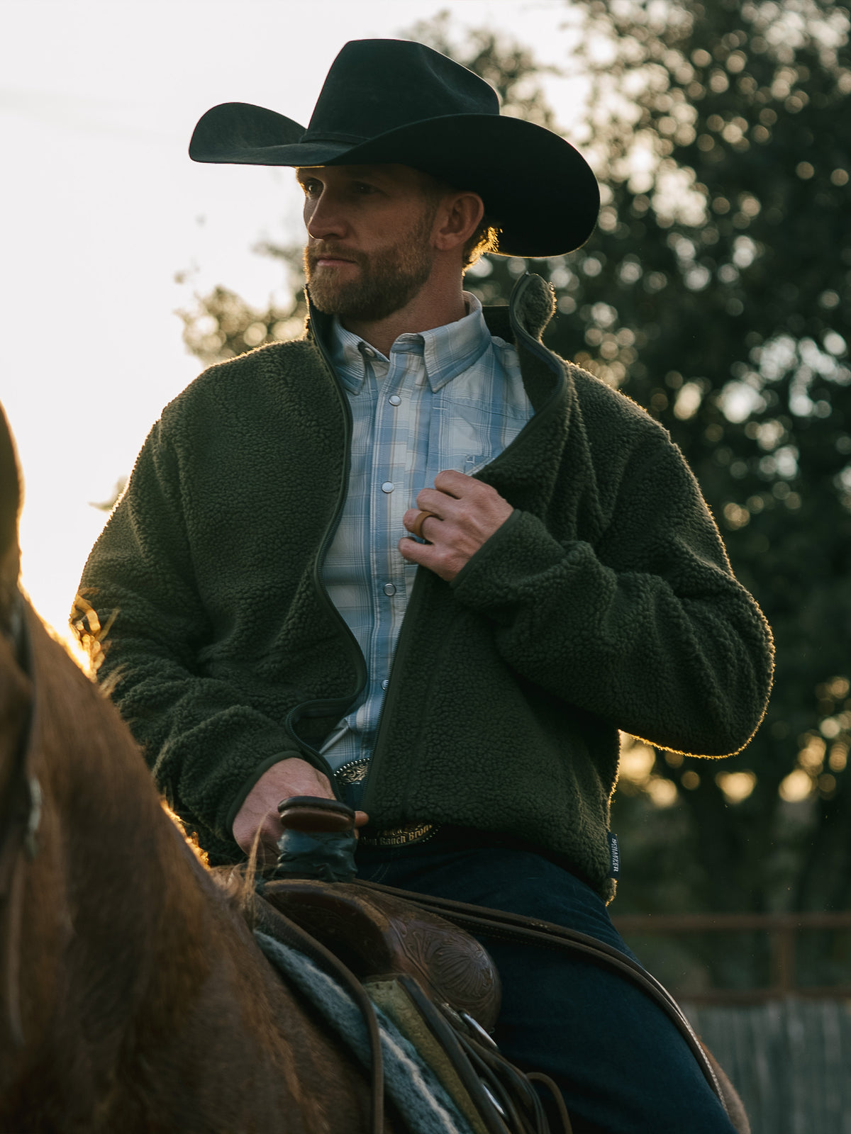 Olive full-zip fleece jacket on a man outdoors, zip front and thick fleece texture.