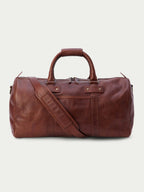 Russet leather weekender duffel bag with adjustable shoulder strap and zip top.
