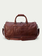 Russet leather weekender duffel bag with top handles, zip closure, and shoulder strap.