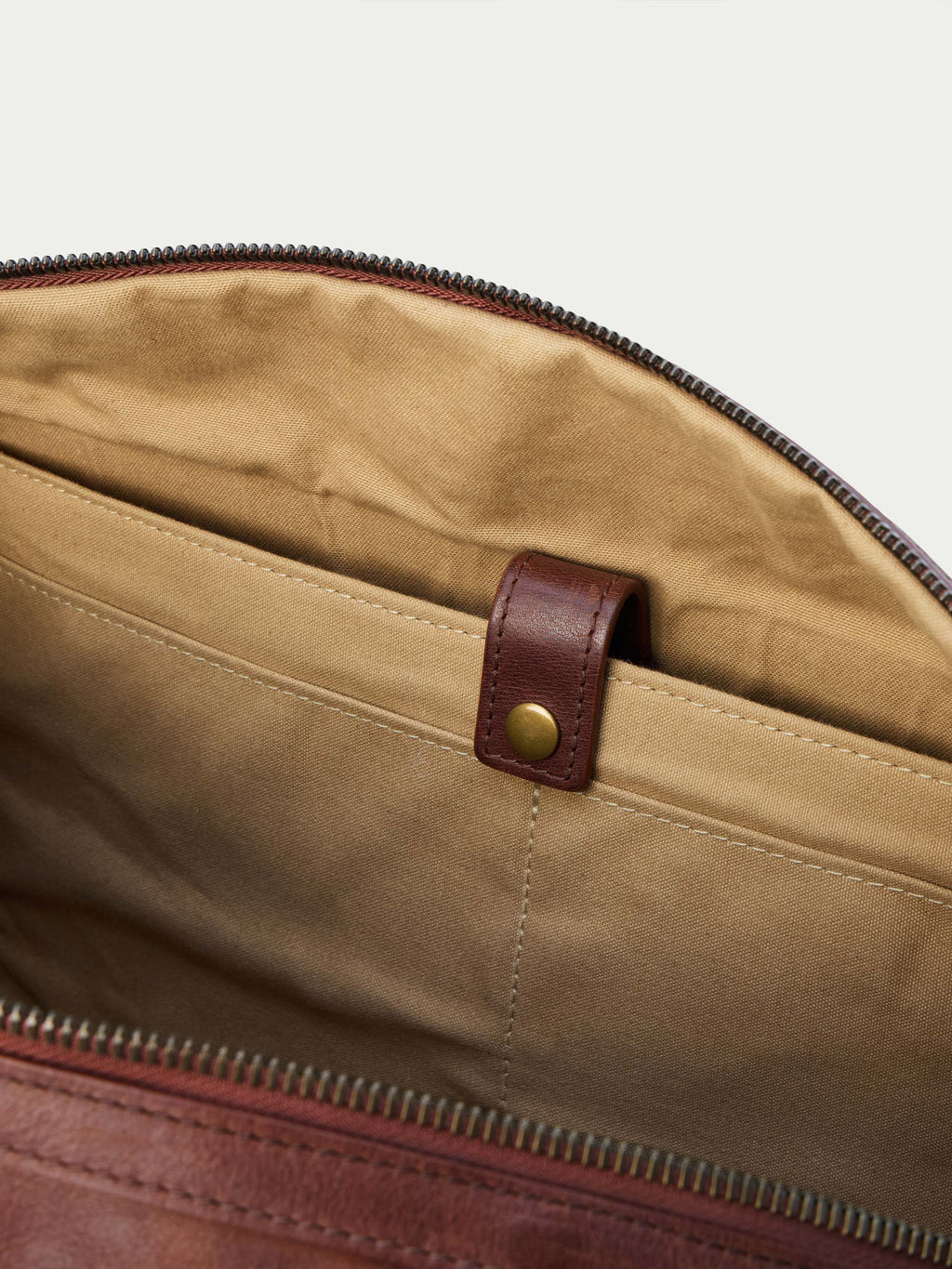 Russet duffel interior with zip pocket and leather tab snap.