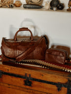 Russet leather weekender duffel bag with matching small crossbody pouch.