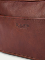 Russet leather dopp kit with embossed logo on front and zip closure