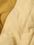 Tan quilted nylon vest panel close-up with stitched channel seams