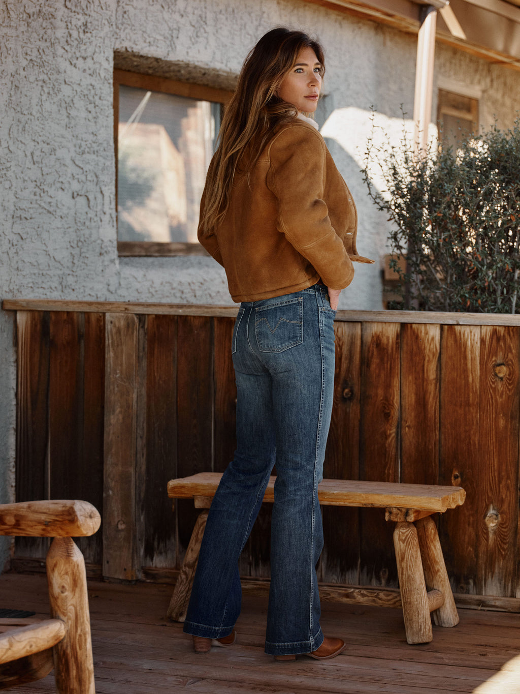 Medium-wash straight-leg jeans on model, side view with stitched back pockets.