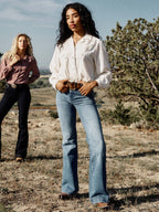 Medium wash denim jeans with wide straight leg and classic five-pocket styling