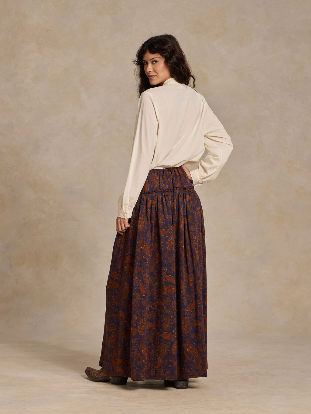 Back view of paisley maxi skirt, dark blue with rust-orange swirls and gathered waist.