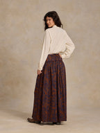 Back view of paisley maxi skirt, dark blue with rust-orange swirls and gathered waist.