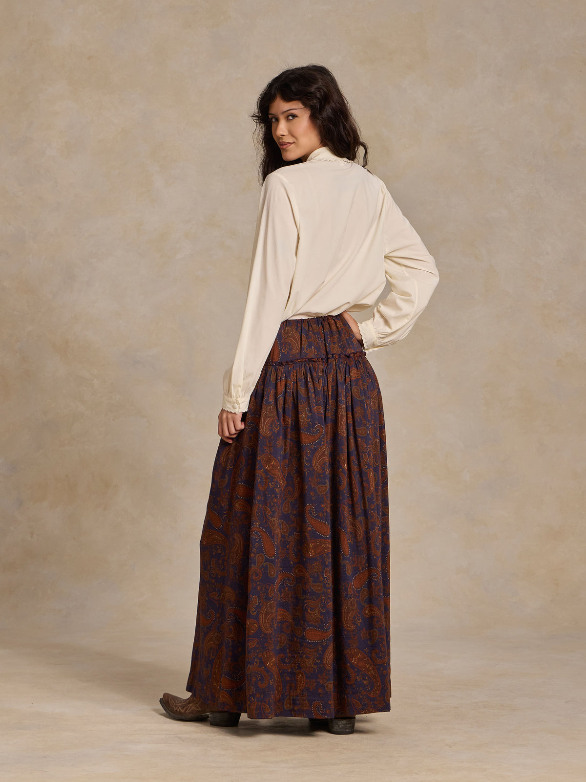 Back view of paisley maxi skirt, dark blue with rust-orange swirls and gathered waist.