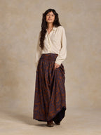 Paisley maxi skirt with elastic waistband, dark blue fabric with rust-orange motifs.