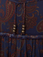 Elastic waistband on dark blue paisley skirt with rust tones and bead drawstring details.