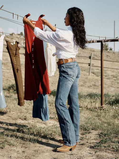 Medium-wash denim jeans, straight fit, contrast orange stitching and front pockets.