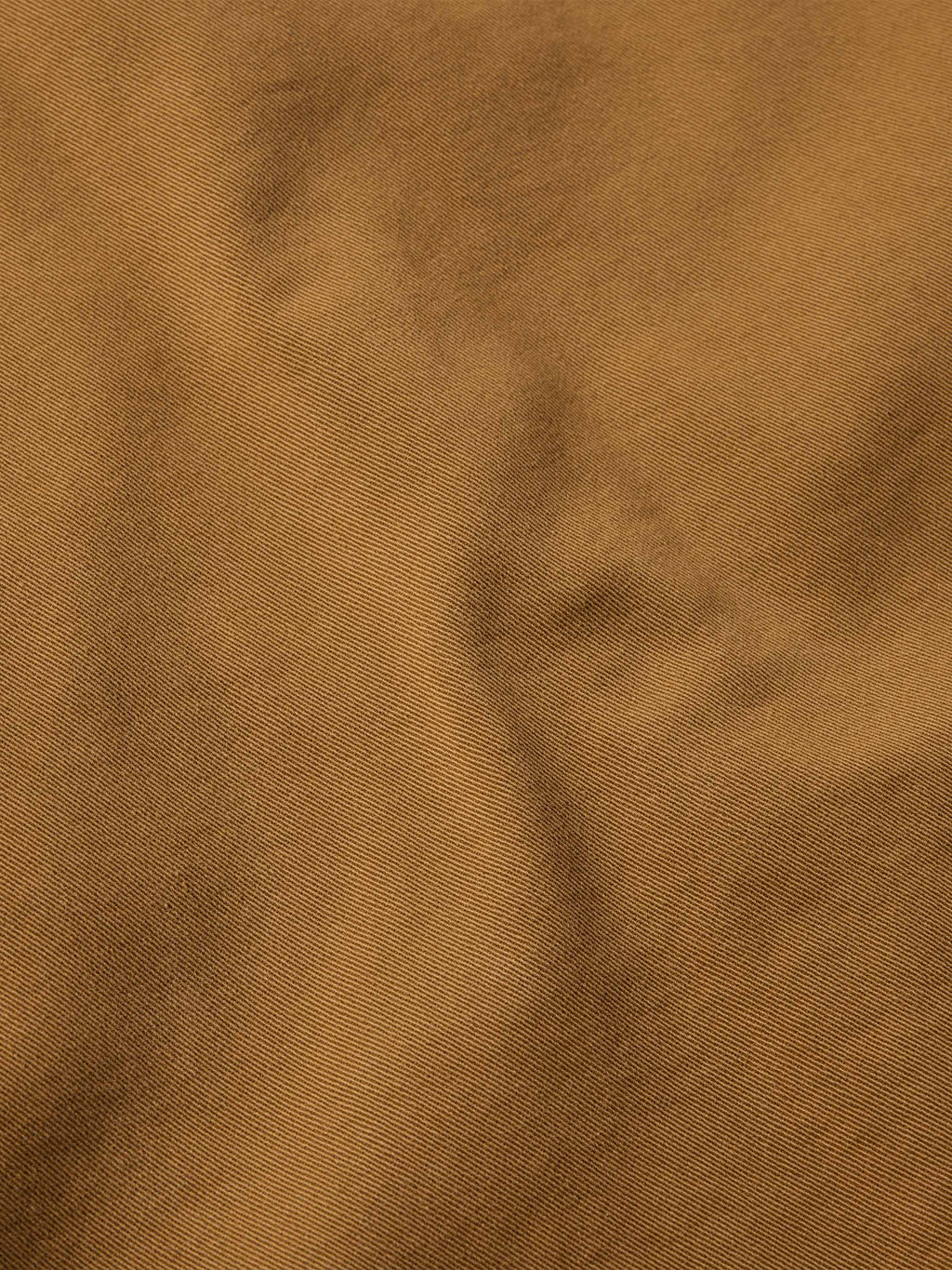 Close-up of fawn denim fabric texture with fine twill weave.