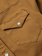Fawn denim shirt chest pocket with flap and snap button detail.