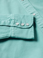 Turquoise women's snap-front denim shirt front: chest pocket flaps with silver snaps