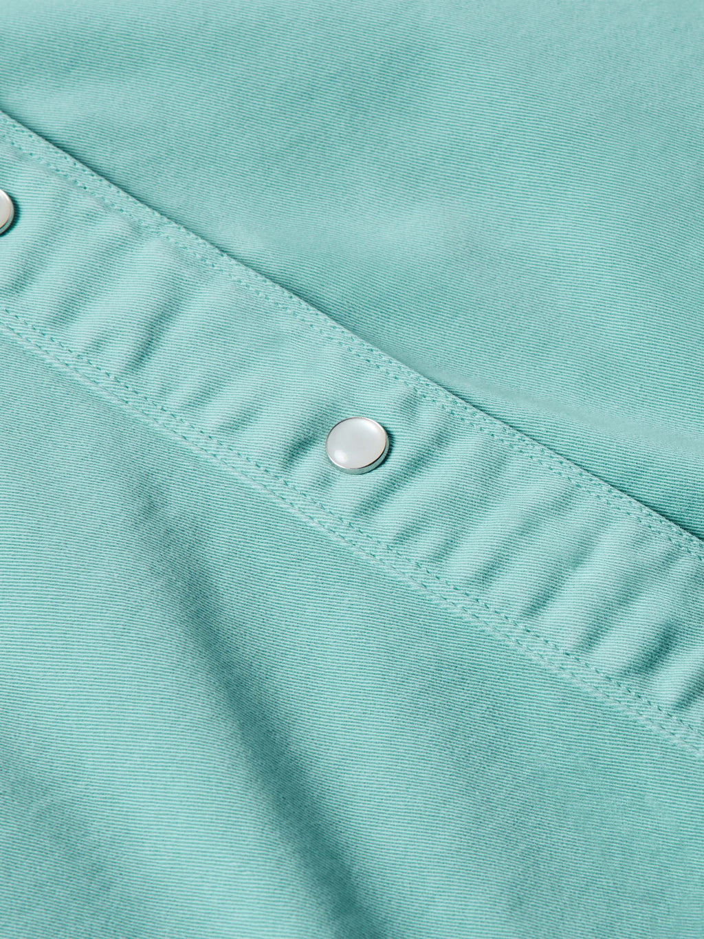 Turquoise women's snap shirt seam detail with silver snap and stitched placket