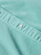 Turquoise women's snap shirt seam detail with silver snap and stitched placket