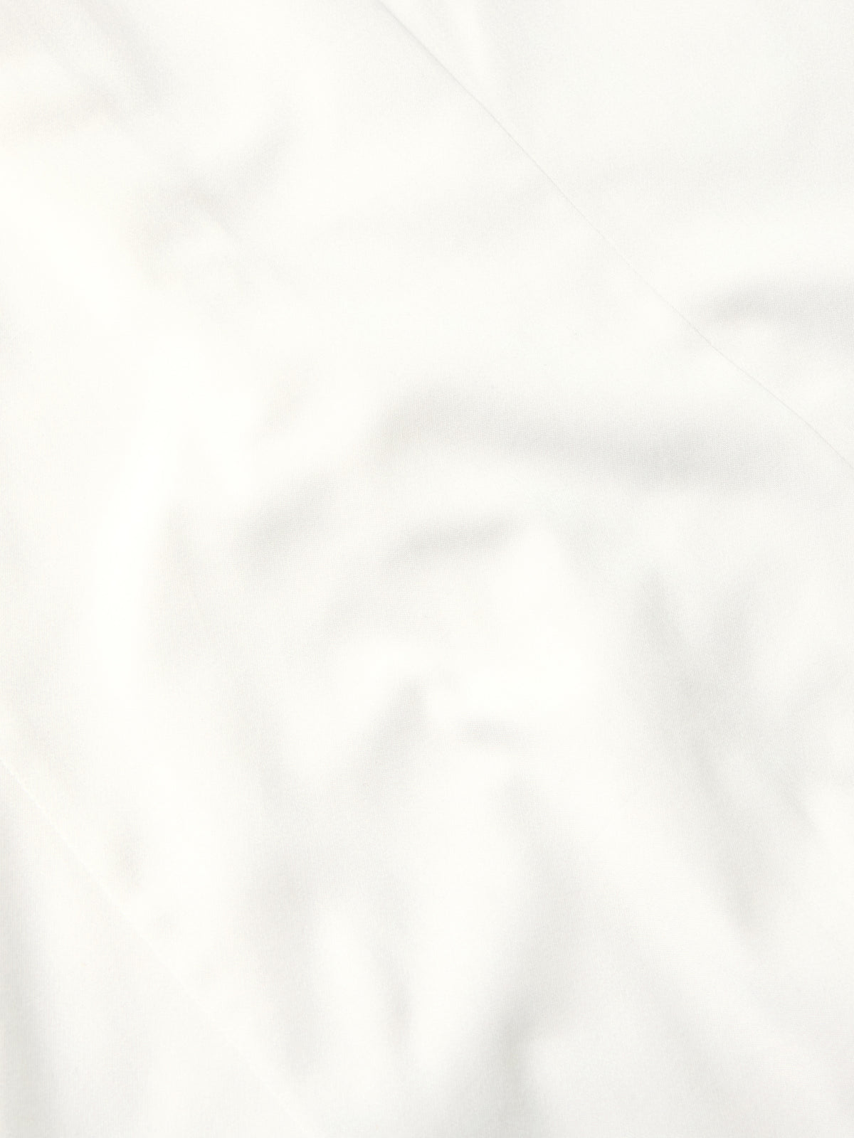 White shirt fabric close-up with smooth weave and subtle creasing
