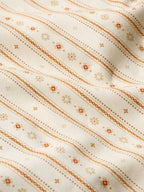 Women's printed button-up shirt fabric close-up with orange and tan striped pattern
