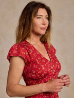 Red floral V-neck wrap-style dress with cap sleeves, button front, tied waist