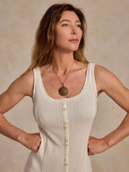 Bone sleeveless dress with scalloped neckline trim and central button front