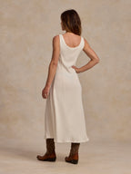 Bone sleeveless dress from back with curved neckline and midi length