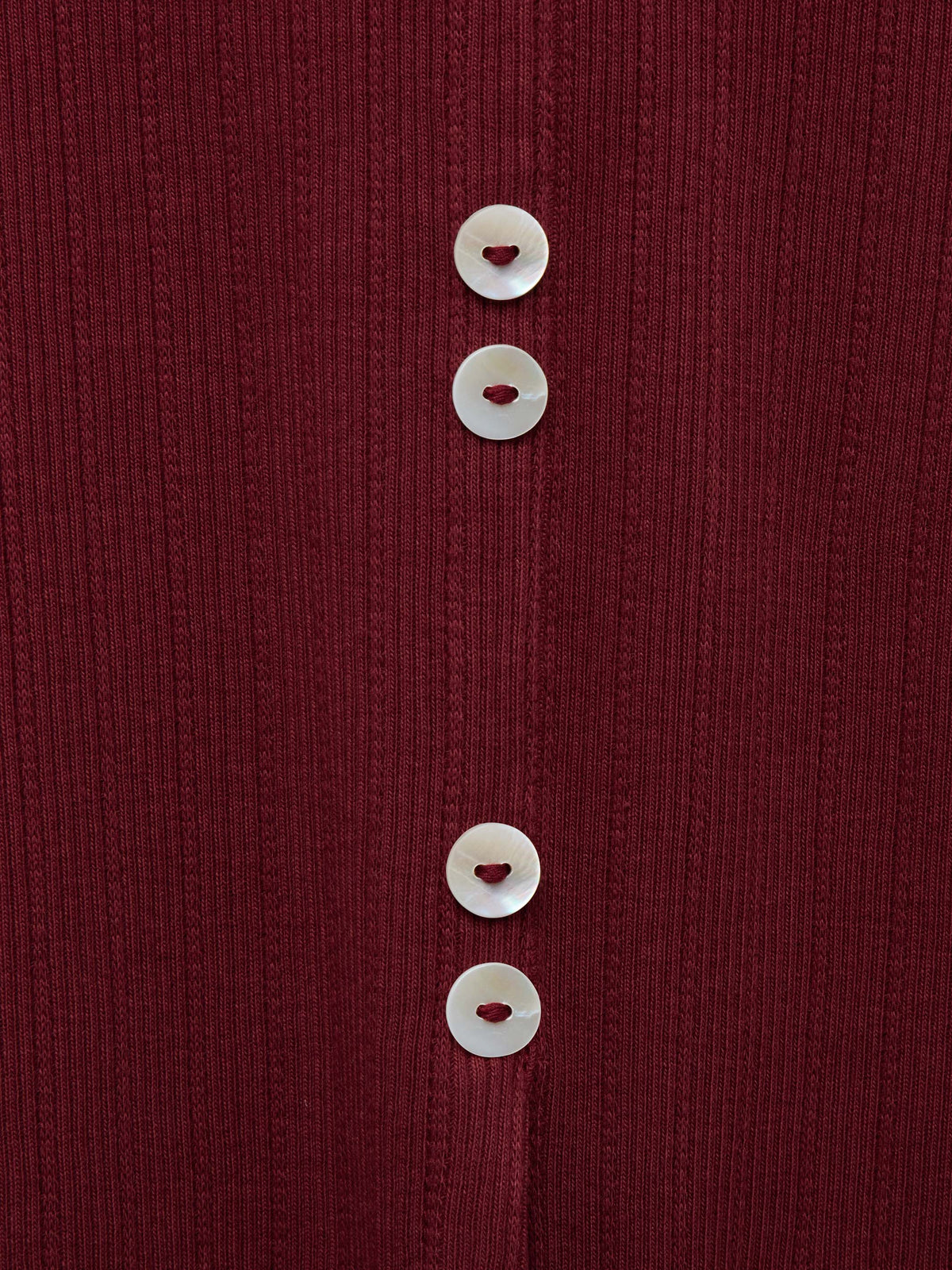 Wine ribbed knit fabric close-up with white button trim