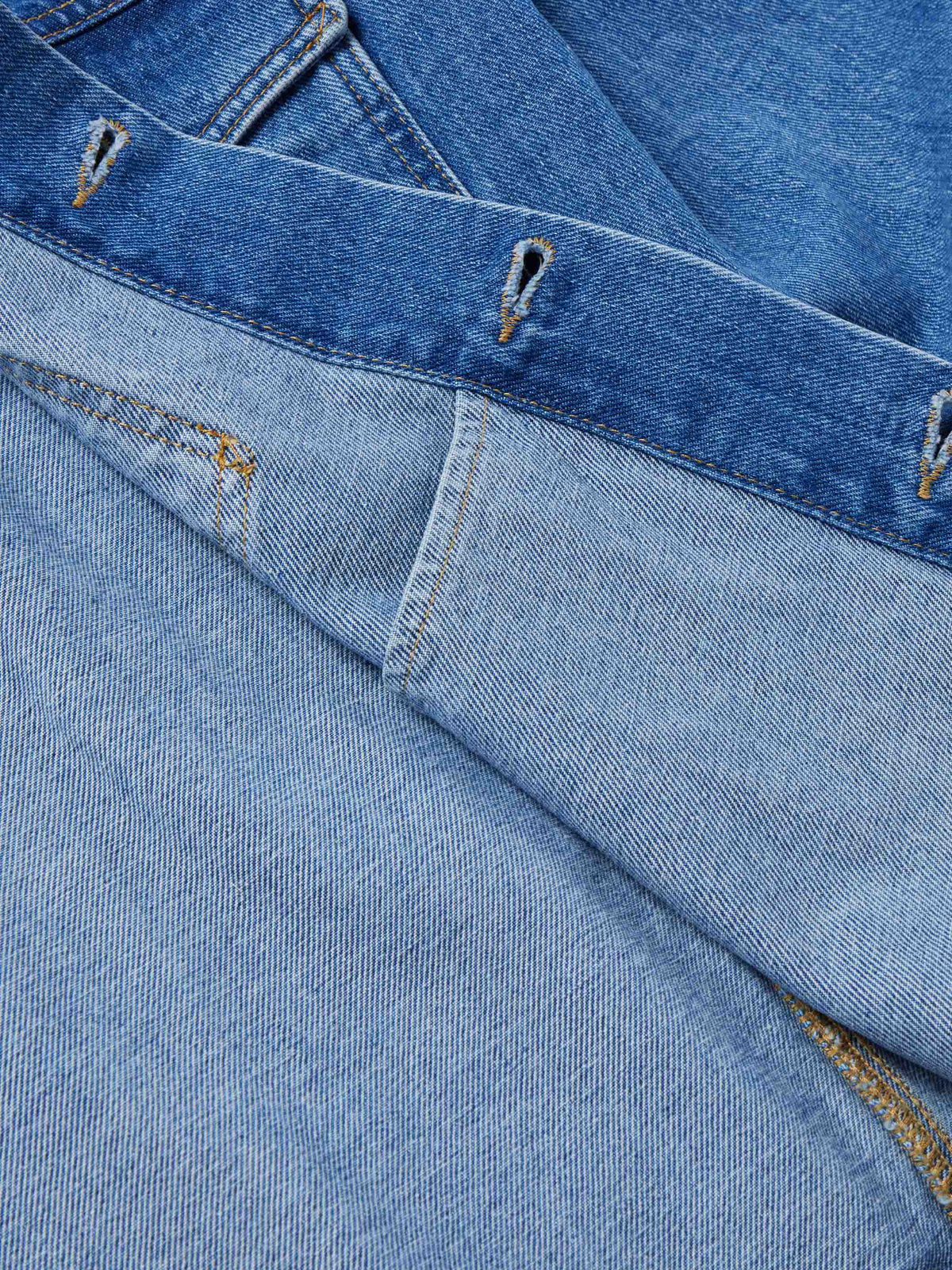 Indigo denim jacket yoke seam and contrast topstitching with metal snaps