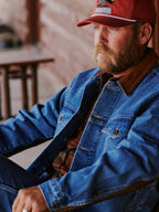 Man wearing medium indigo denim jacket with brown collar and chest pockets