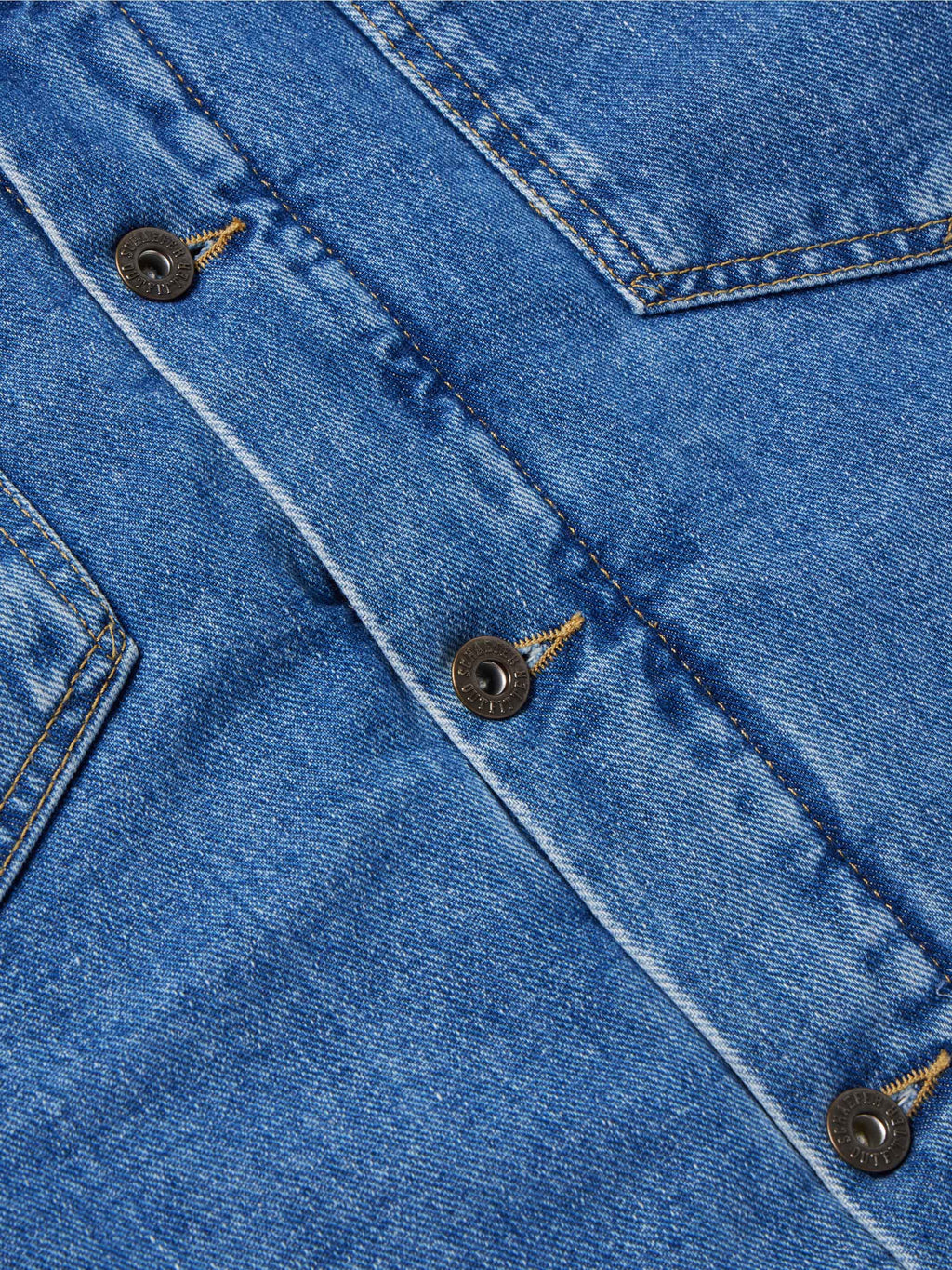 Indigo denim jacket chest detail with flap pockets and metal snap buttons