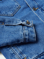 Indigo denim jacket cuff with adjustable button strap and metal hardware
