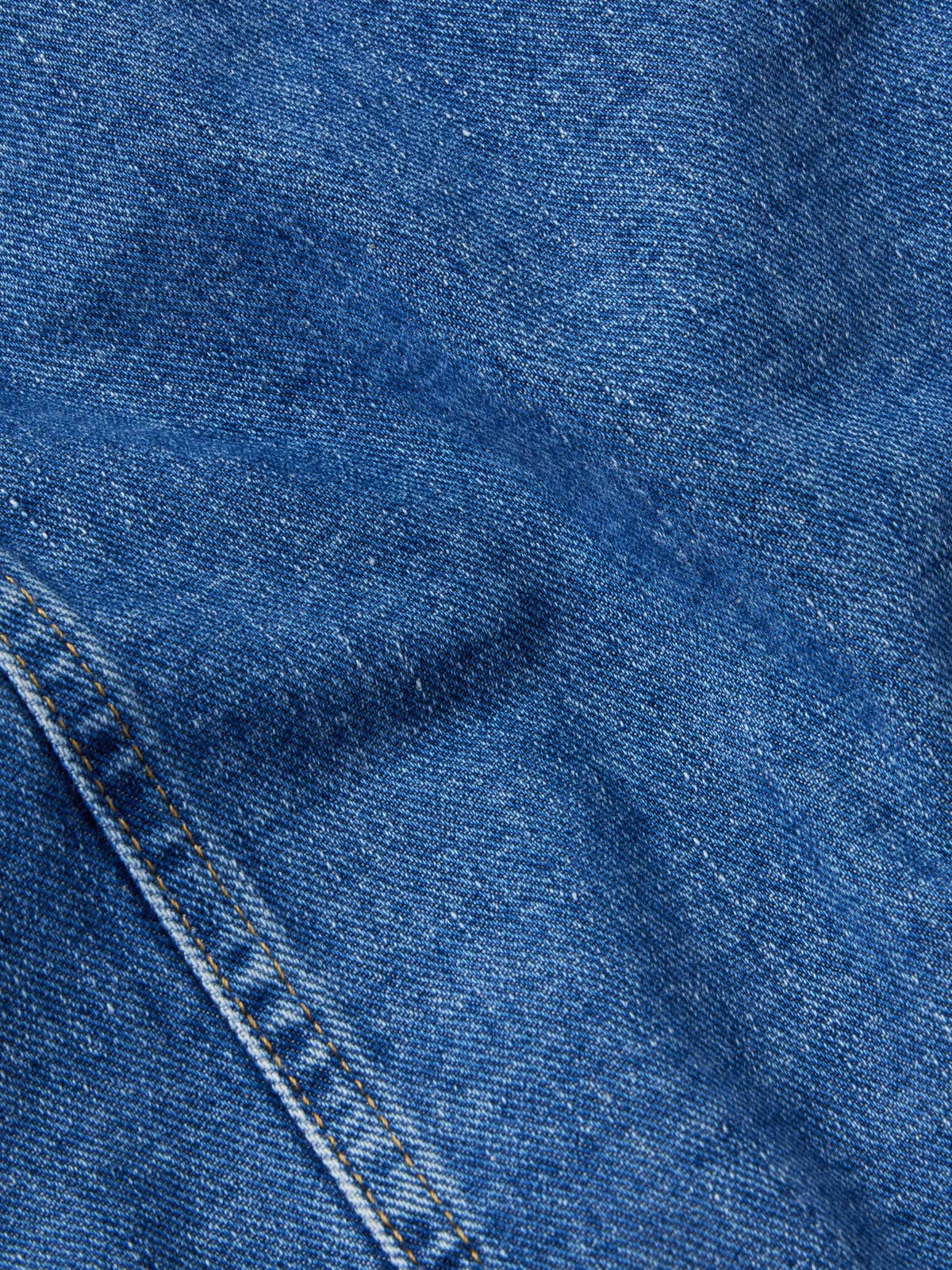 Indigo denim jacket fabric texture with stitched seams and paneling