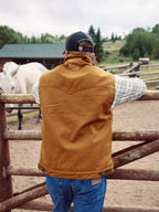 Men’s tan canvas zip-up vest with cream sherpa lining and stand collar