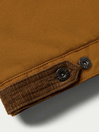 Sandstone canvas vest hem with dark ribbed lining and two snap buttons
