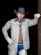 Beige drifter coat with brown top stitching, snap front, side pockets, and gloves