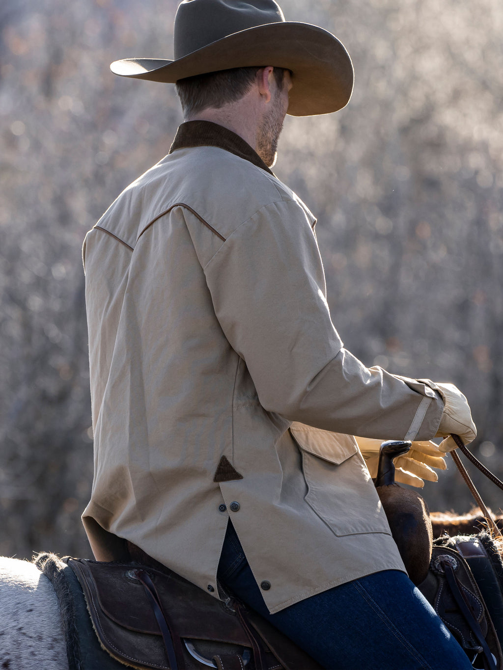 Back view of beige drifter coat with brown yoke trim and flap pockets