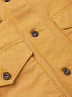 Suntan brush jacket close-up with button placket and metal snap details.