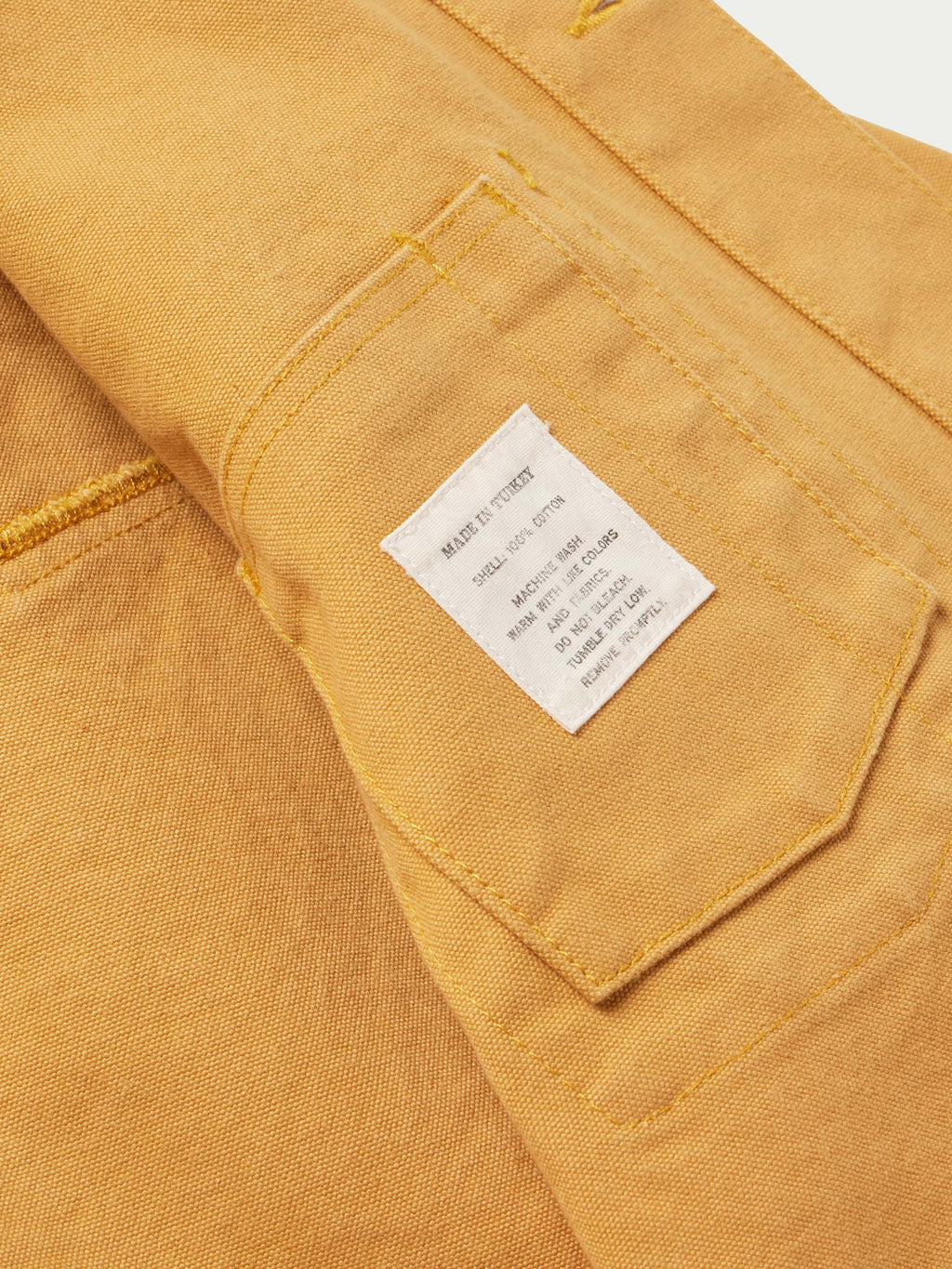 Suntan brush jacket interior pocket with stitched hem and sewn label.