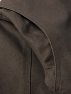 Dark brown canvas jacket shoulder seam and pocket edge close-up