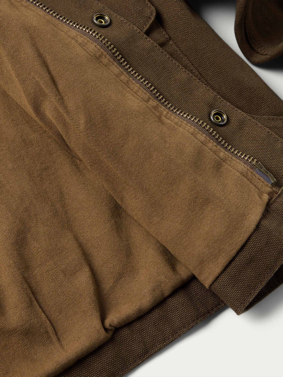 Hickory canvas jacket detail: angled chest pocket with flap snaps and metal eyelets