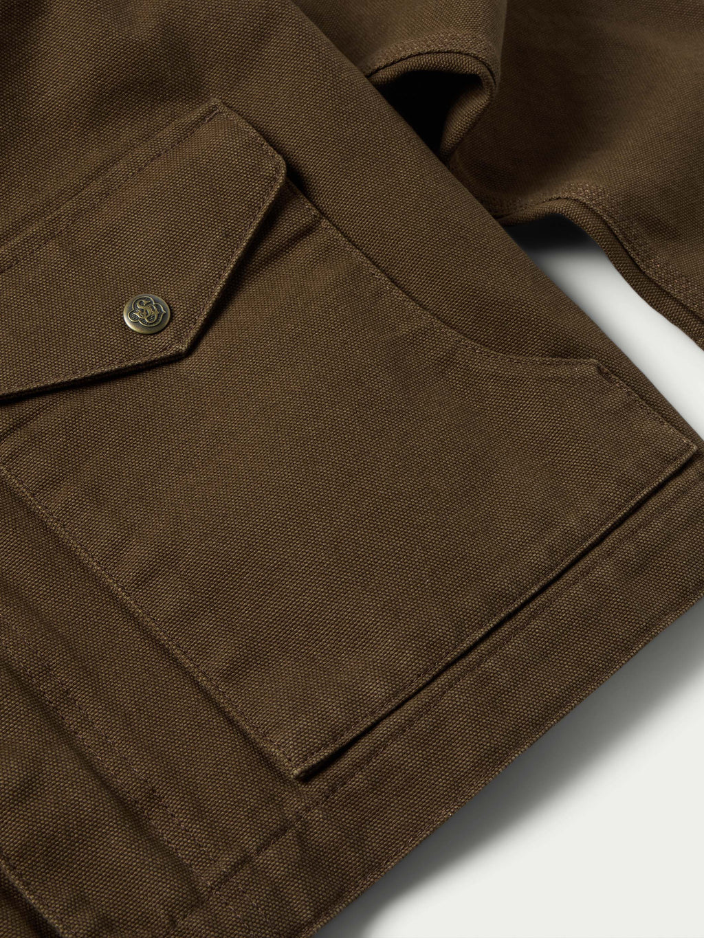 Hickory canvas jacket shoulder yoke detail with metal snap and seam stitching