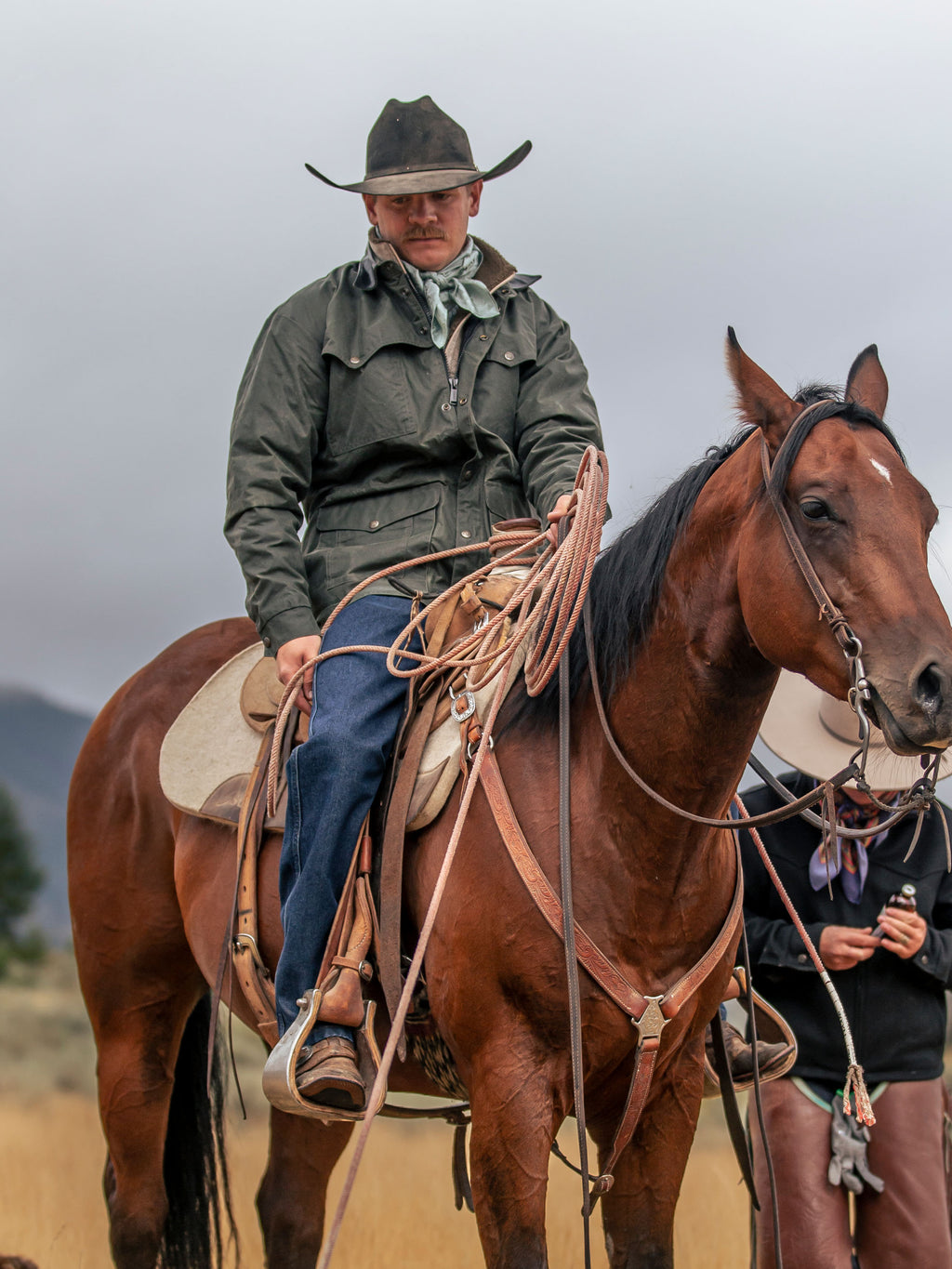 Dark green drifter jacket with brown leather-style collar worn outdoors by a rider