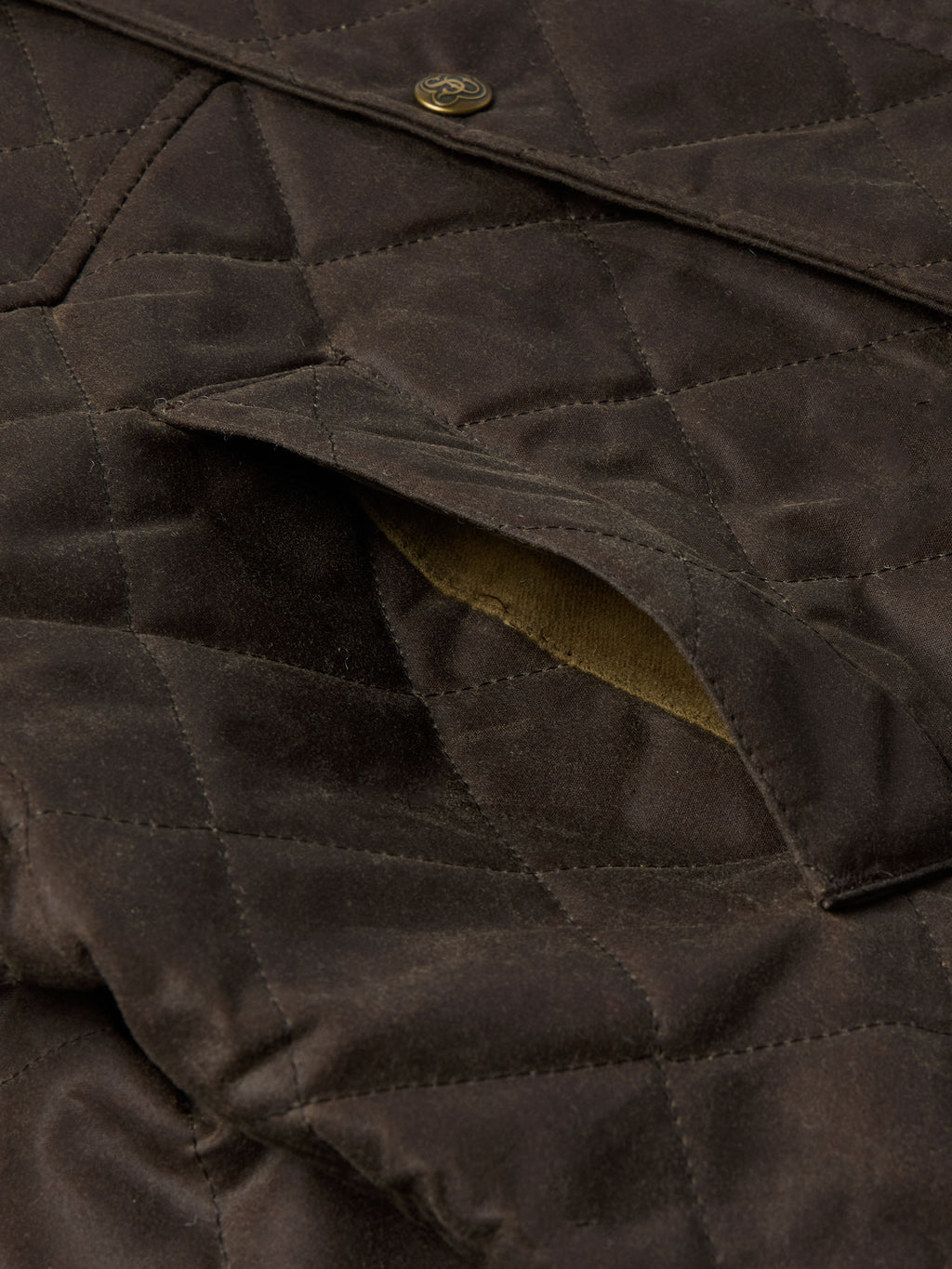 RangeWax® jacket close-up of dark brown quilted fabric and seam stitching