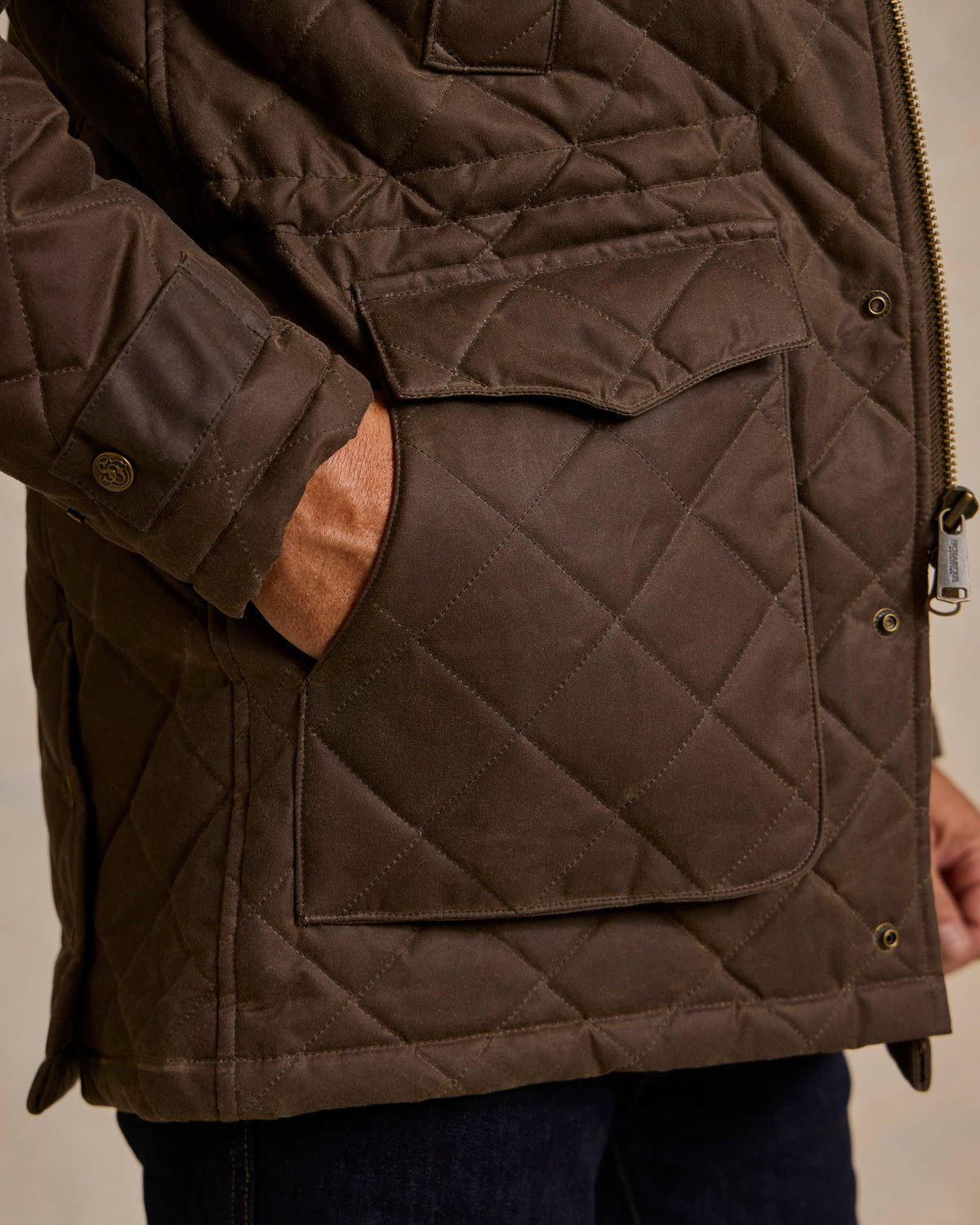 Brown quilted jacket with zip front, chest flap pocket, and snap button cuffs