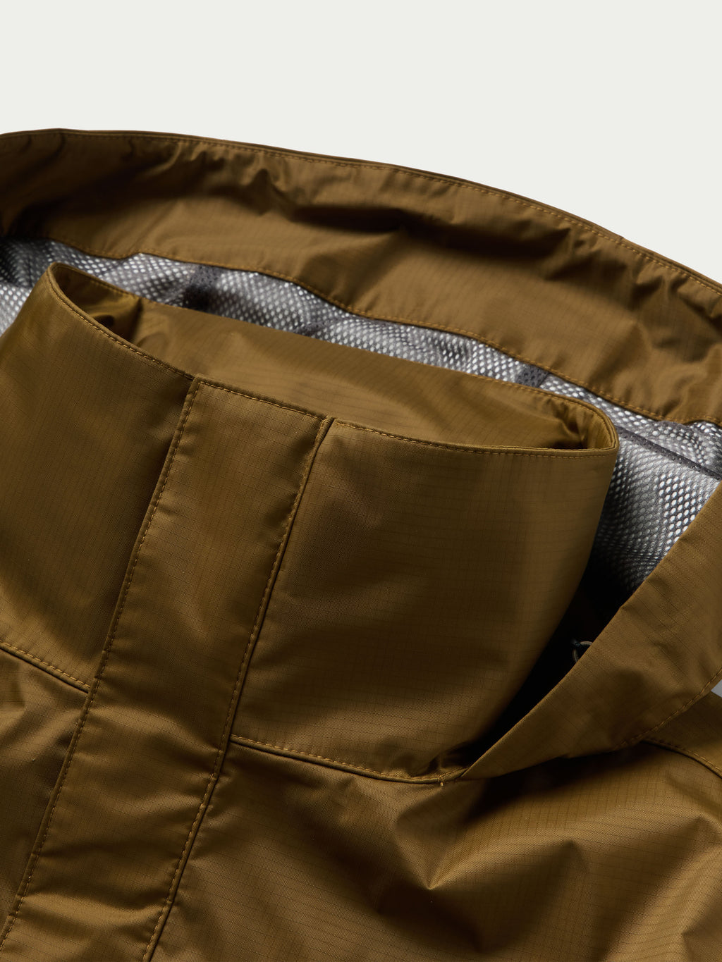 Brown rain jacket lining and inner pocket view from open hood area