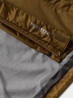 Brown rain jacket interior with brand label near zipper seam